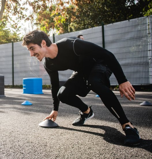 Athlete sprinting through an outdoor functional fitness circuit