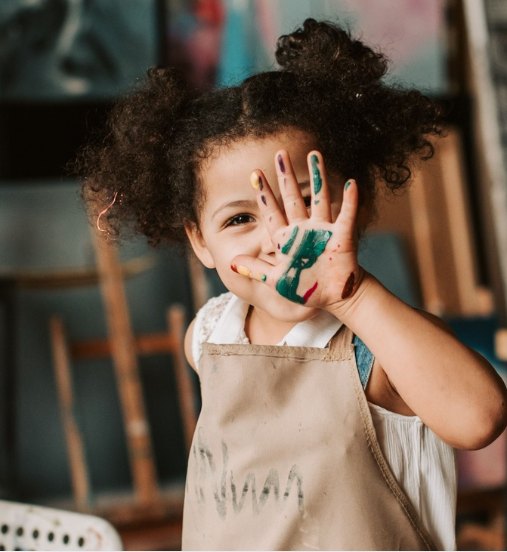 Child with paint on their hands at a creative workshop