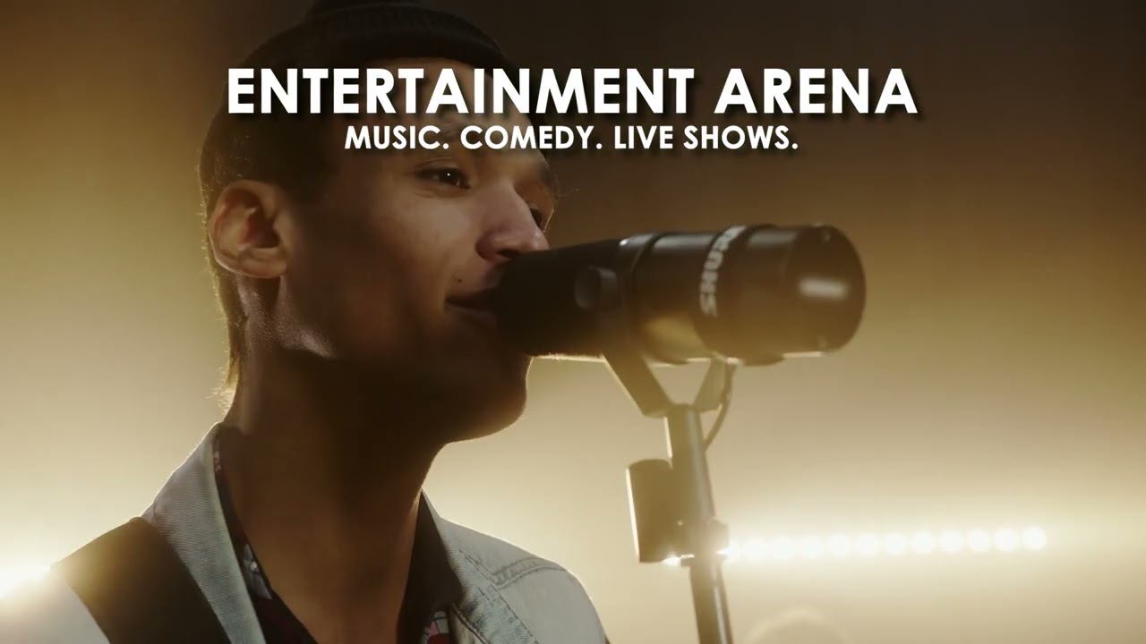 A singer performing into a microphone on the Entertainment Arena stage